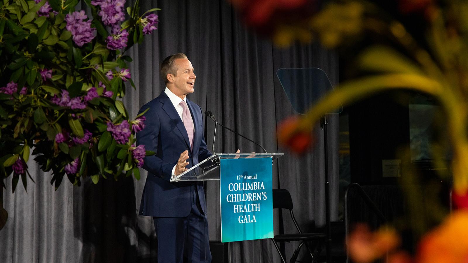 Emcee standing at the podium speaking at a gala