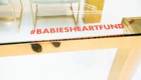 image of table with #BABIESHEARTFUND written on it